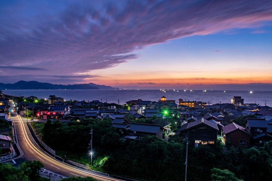 夕陽の余韻を受け継ぐように、水平線に灯る漁火。 初夏の丹後に訪れる、美しい夜のはじまりです
