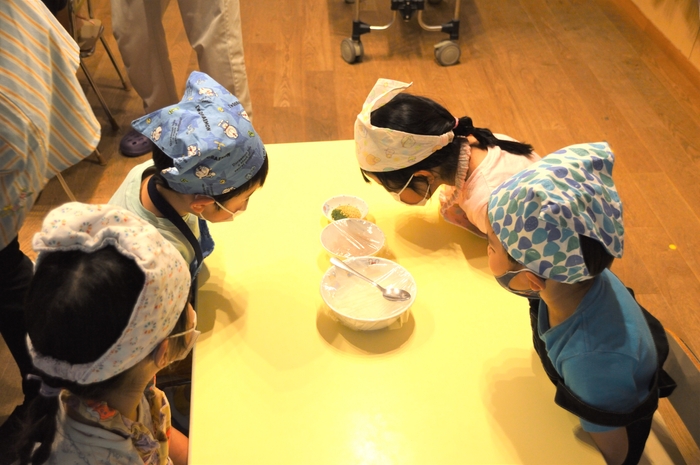 配られたごはんを覗き込む子どもたち