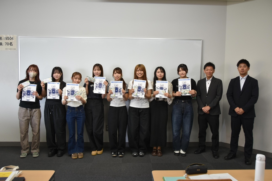 報告会で発表した8人の学生と名鉄タクシーホールディングスの山口部長と脇田課長補佐