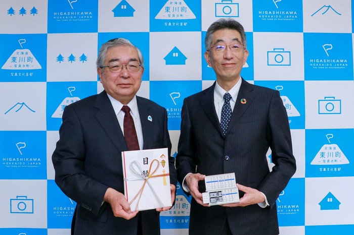 松岡市郎 東川町長(左)、日本ガイシ株式会社 専務執行役員 石川 修平氏(右) 。石川氏が手に持つのはNAS®電池の1/50模型。