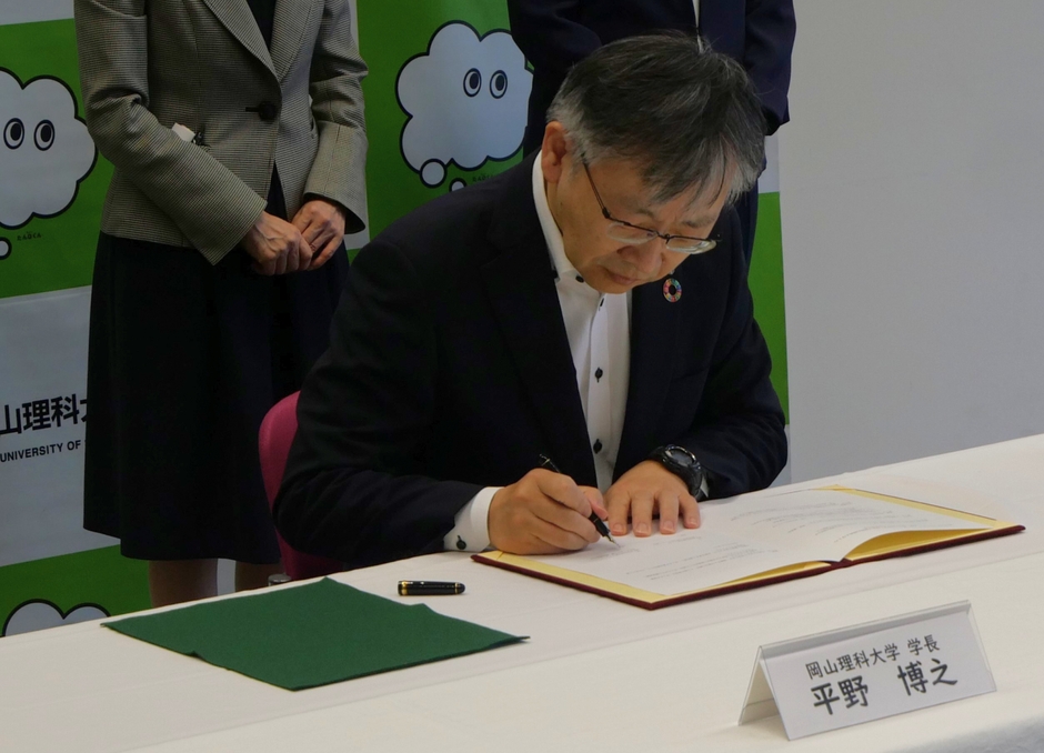 協定書に署名する平野学長