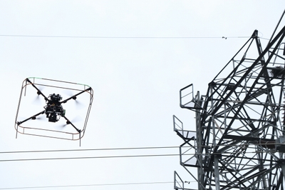 実証実験で送電線の上を飛行するドローン＝栃木県佐野市のＪパワー送電技能訓練センター