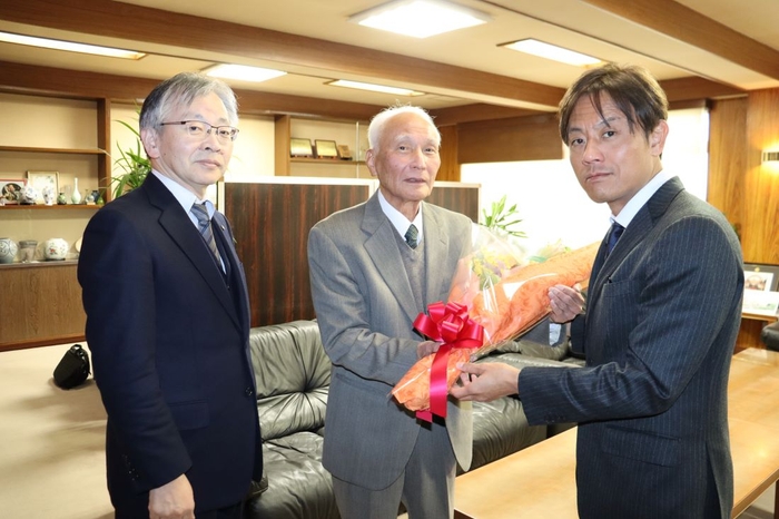 加計理事長（右）から花束を贈られる善木名誉教授（中央）。左は平野学長