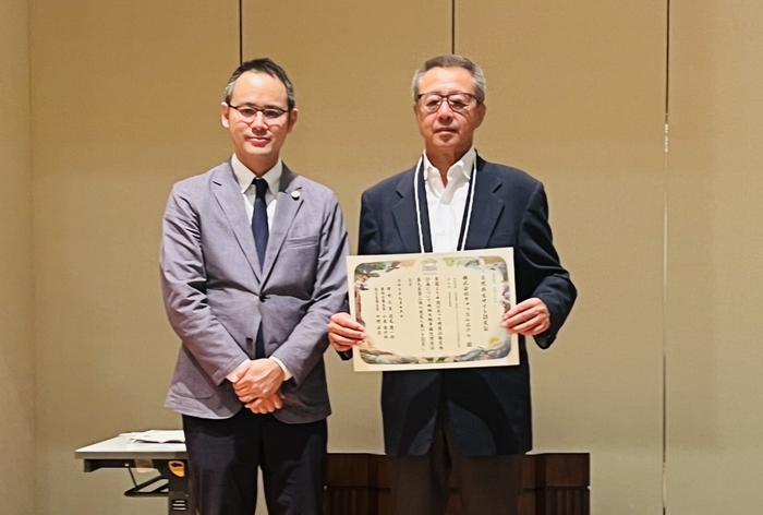 自然共生サイトの認定証を手にする成田社長(右)