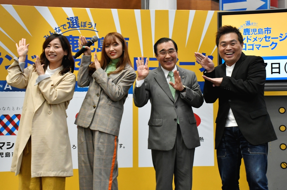 全員でねおさんの決めポーズ「シャキーン!」(左から、新坂恵梨さん(司会)、ねおさん、森博幸鹿児島市長、野口たくおさん(司会))