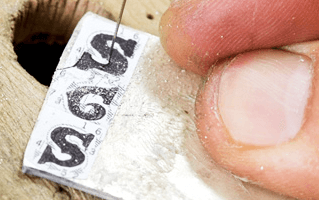 職人の手により一文字ずつ糸鋸（いとのこぎり）で切り出しを行います。数ミリ単位の非常に細かい作業を全て手作業で行います。 フォントはストロークを組み合わせて形作った、まっすぐな線が少ないデザインです。