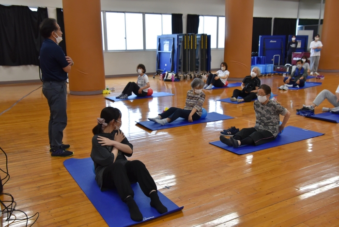 梅田教授（左）らが指導し、学生も一緒に運動