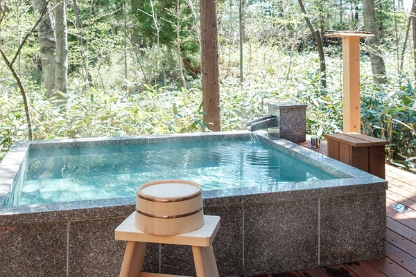 森に点在するコテージ型のお部屋。温泉の熱を回収するシステムを導入済