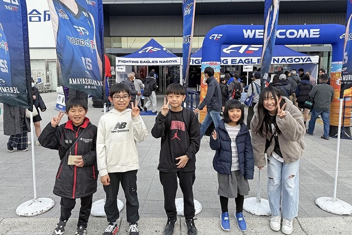 試合会場の前でワクワクした様子で写真撮影をするQQキッズたちの様子