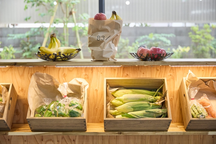 カウンターに季節の野菜や果物が並び、これらを紙袋に詰めて持ち帰れる