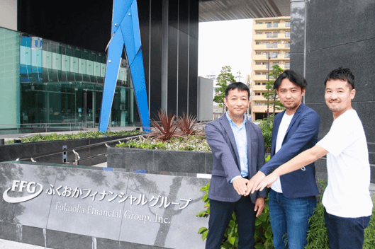 FFG本社ビル前にて 左からFFG藤井、ラシン原、武