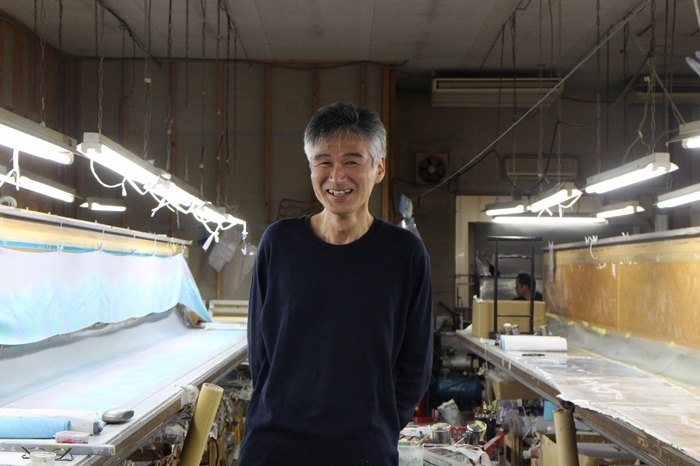 京友禅師の福田さん。「京友禅の魅力は繊細な表現ができること。色を細かく重ねていきながら、ひとつひとつ丁寧に描きました 。マスクに咲いたこの小さな花を少しでも楽しんで頂ければ嬉しいです。」