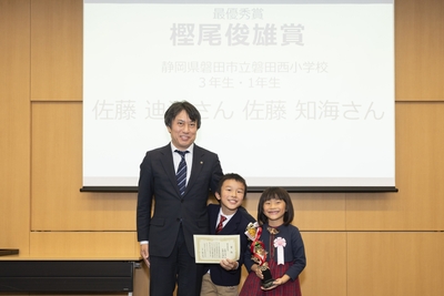 樫尾俊雄記念財団 樫尾隆司理事長と、樫尾俊雄賞を受賞した佐藤 迪洋さん・知海さん 記念写真
