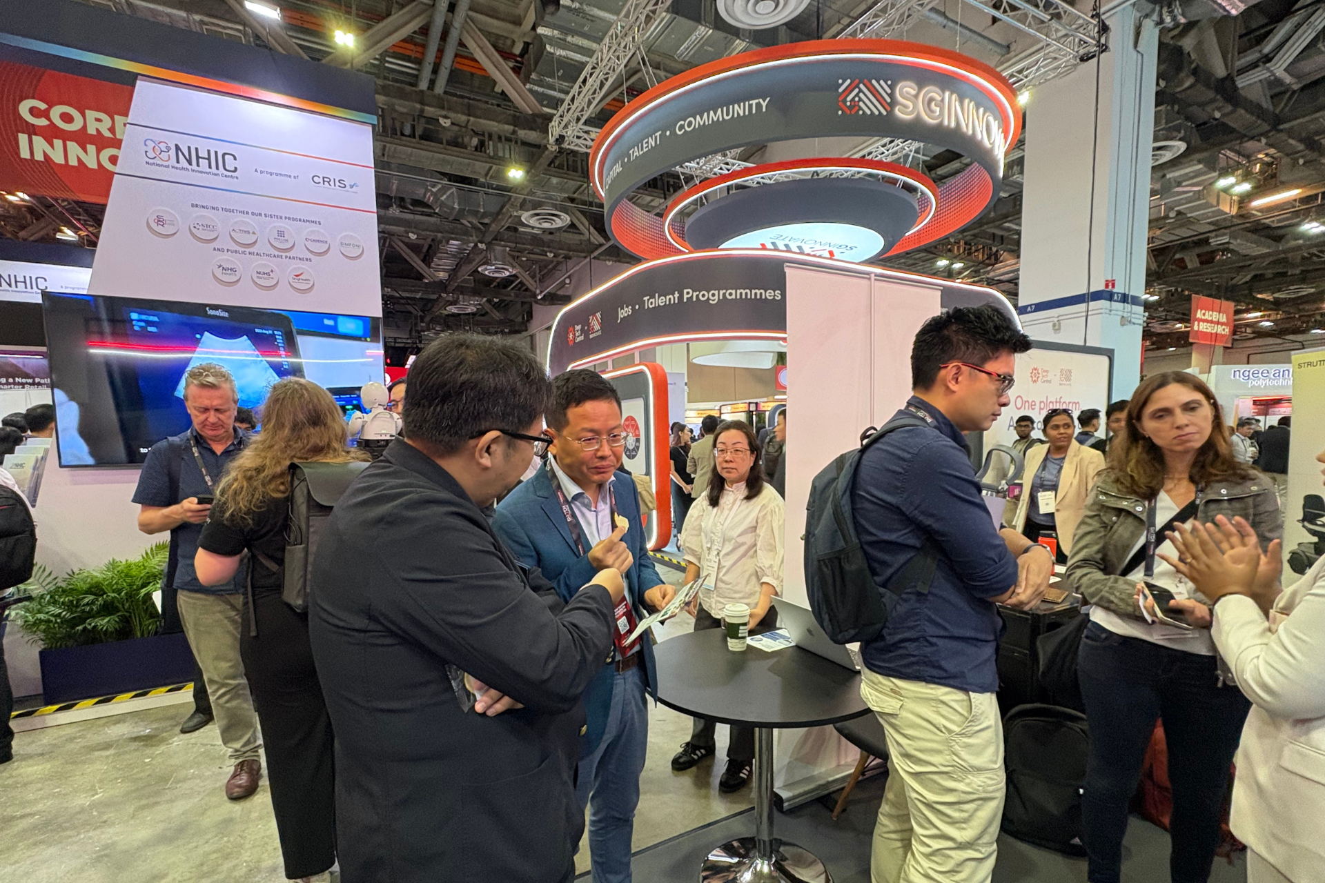 ブースを訪れた人に説明するトイメディカル株式会社代表取締役社長 竹下英徳(左)