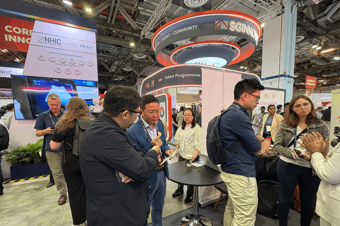 ブースを訪れた人に説明するトイメディカル株式会社代表取締役社長 竹下英徳(左)