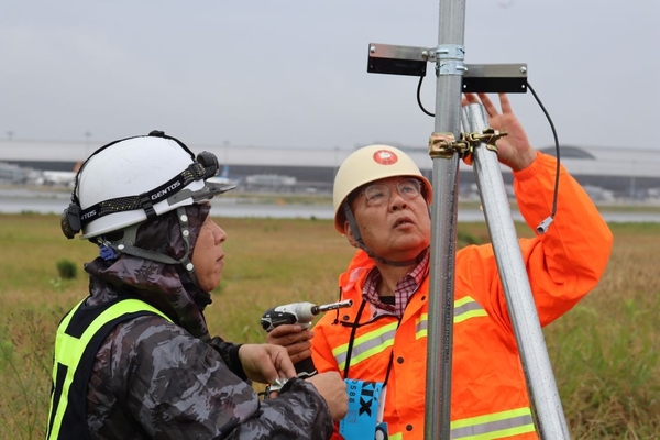 スピーカーの向きを調整する辻特坦教授（右）と轟社長（左）