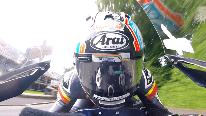 疾走するライダーのすぐ脇には民家