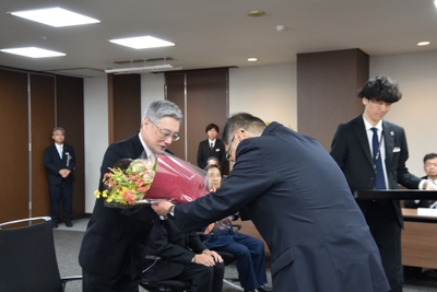 小原章裕理事長から花束を贈られる伊藤名誉教授