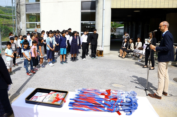 高知 代表:ハンス・ブランケンが児童に傘を贈呈
