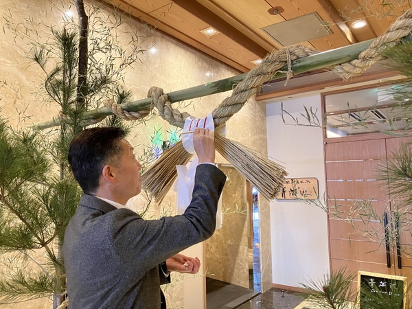 「ケンダイ」と呼ばれるしめ縄の中央に紅入れをする様子