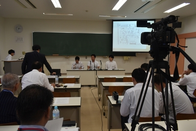 模擬記者会見する幹部役の学生(中央3人)ら
