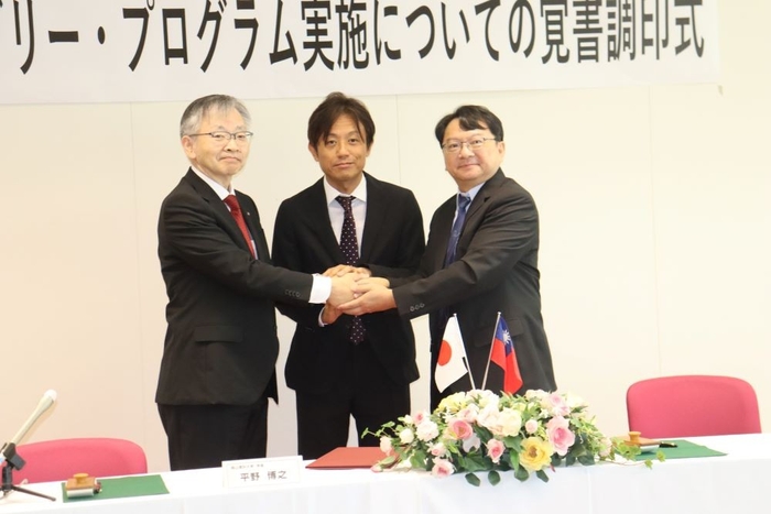 覚書調印後、がっちり握手する(左から)平野学長、加計理事長、呂学長