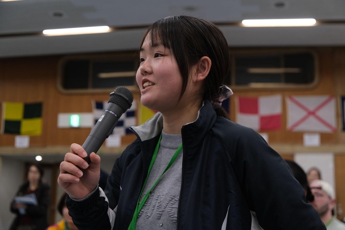 (力強く英語で発表をする高校生)