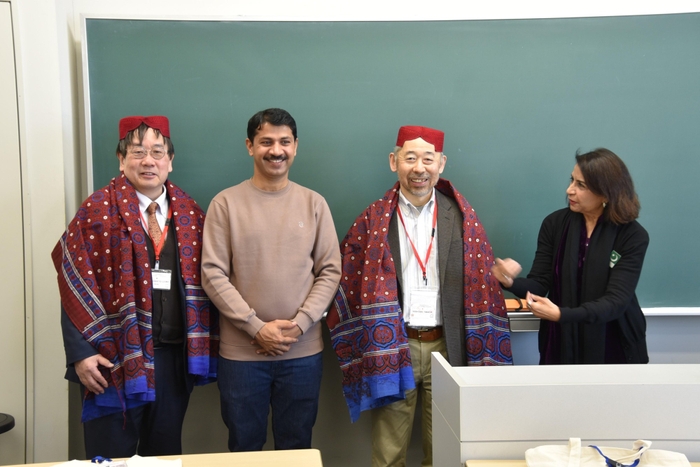 帽子とショールを贈られた神野学部長（左端）と高谷准教授（右から２人目）