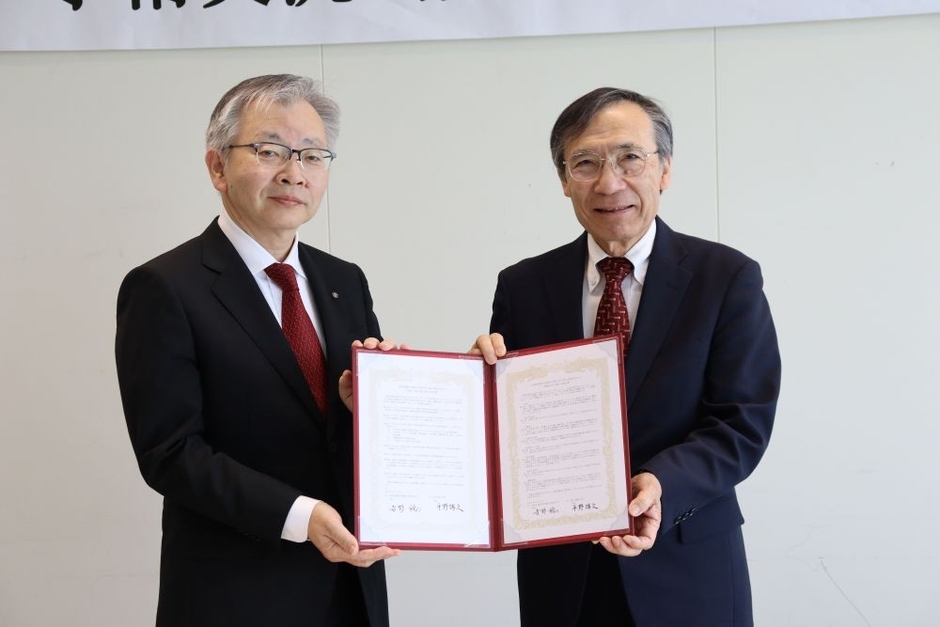 協定書を掲げる(左から)平野学長、寺野学長