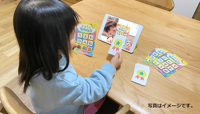 離れた場所にいる友達とビデオ通話で「しりとりBINGO」を遊ぶ4歳の女の子