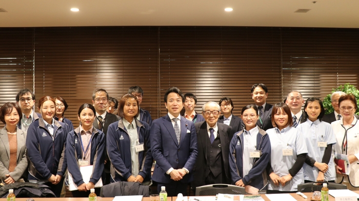 意見交換会終了後の記念撮影の様子(特別養護老人ホーム「ユーカリゆうとの杜」にて撮影)(写真前列中央：濱地副大臣、前列中央右：ユーカリ優都会理事長　嶋田 哲夫、前列右から2、3、4番目および左から3、4番目：意見交換会に出席したユーカリ優都会ミャンマー人職員)