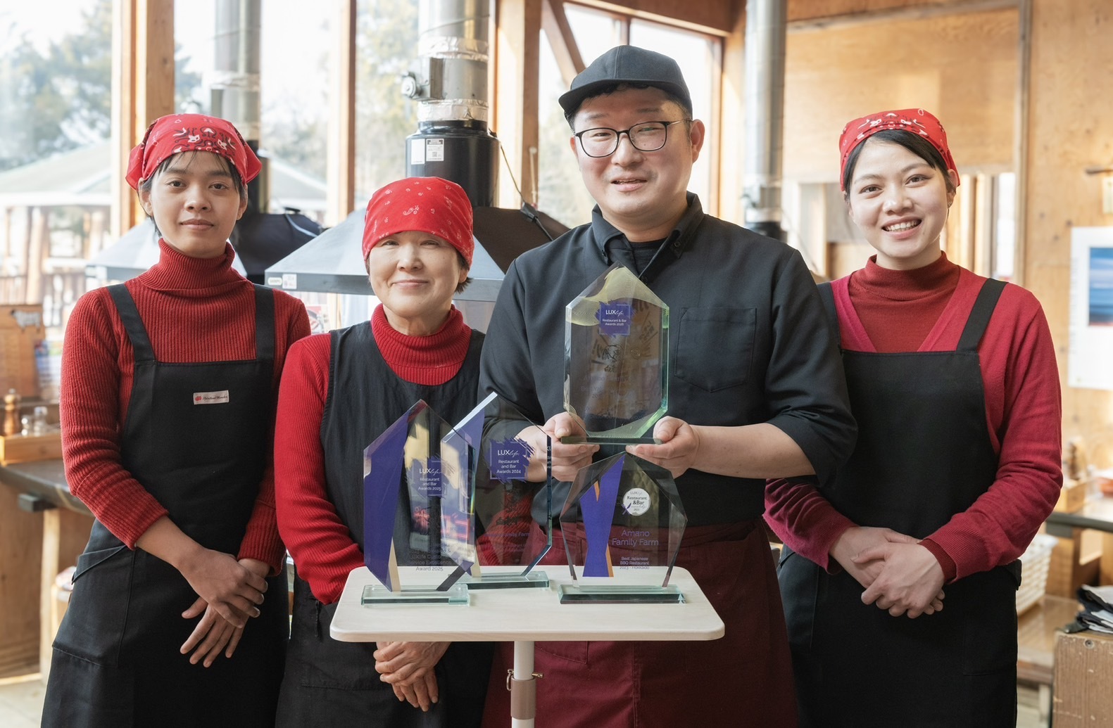 【創業の志を継ぎ、多様なチームで掴んだ世界一】(中央右)代表・天野勝人と、(中央左)創業者の母・志保子。白老牛の伝統を守り続けてきた親子の絆に、2025年より加わったミャンマーからの新戦力が融合。世代と国境を超えた「チーム天野」の結束力が、世界唯一の4年連続受賞という快挙を支えています。