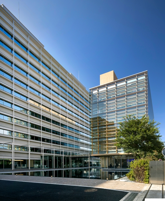 池を継承し、既存建物とも調和するデザインのタクマビル新館(右側の建物)