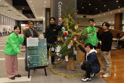 出来上がったツリーを披露する学生たち=岡山キャンパスA1号館で