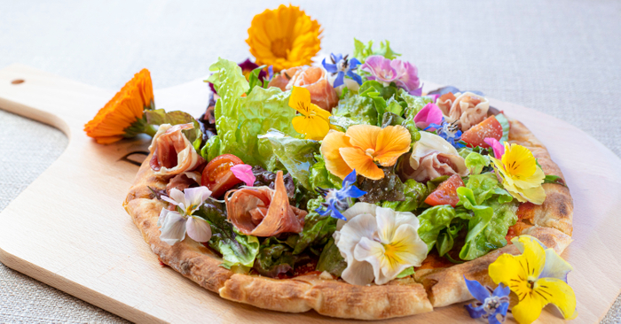 ▲「のじまスコーラ」で提供する春のエディブルフラワーを使用した花束の様な『ブーケサラダピザ』