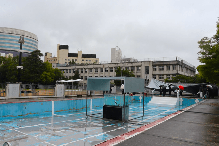 旧内山下小学校の展示会場。右奥がプール、中央が水槽、左側にあるのが展覧会のシンボルとなるAI(人工知能)を搭載した〝しゃべるタワー〟