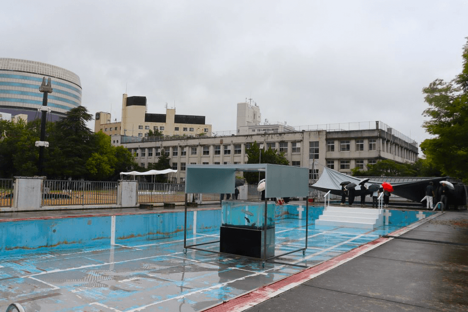 旧内山下小学校の展示会場。右奥がプール、中央が水槽、左側にあるのが展覧会のシンボルとなるAI（人工知能）を搭載した〝しゃべるタワー〟