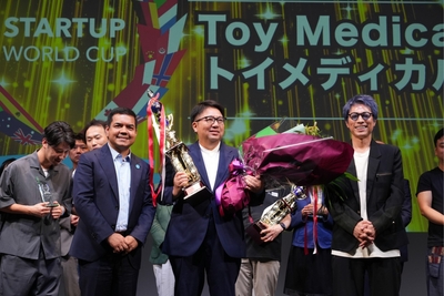 中央:スタートアップワールドカップ2025九州大会にて優勝トロフィーを持つトイメディカル代表 竹下英徳