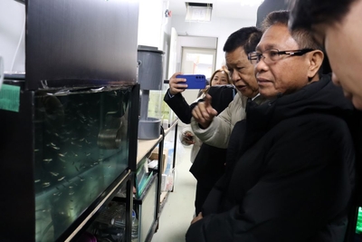 ベニザケとなるヒメマスの稚魚に見入るルイナタ統括部長(右から2人目)ら