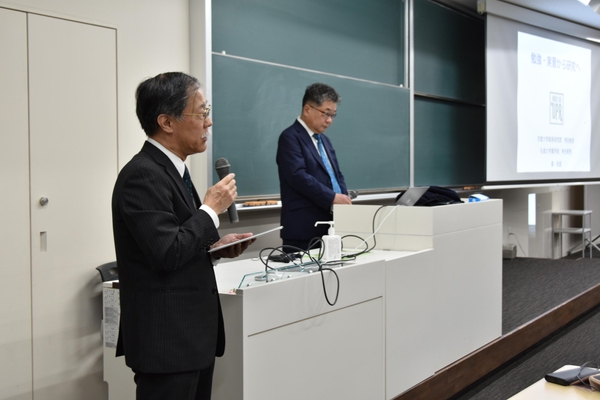 森特任教授を紹介する薬学部の岡本浩一教授（左）