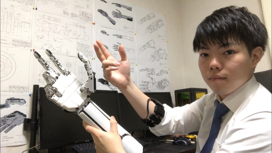 開発中の義手を披露する吉田社長