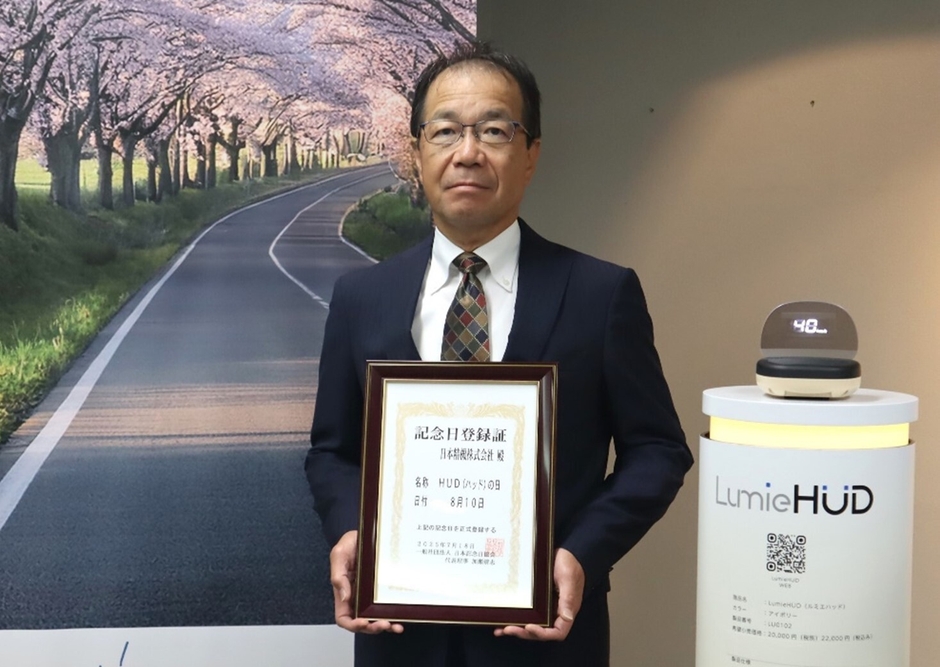「HUDの日」記念日登録証を手にする当社代表取締役会長・佐藤 浩一