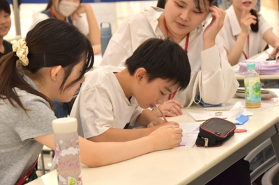 学生たちがサポートしながら宿題に取り組む子供たち