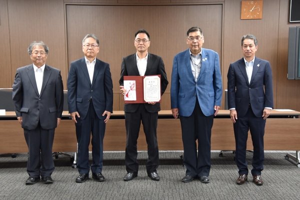 功労賞に選ばれた塚越教授（中央）を囲む小原学長ら