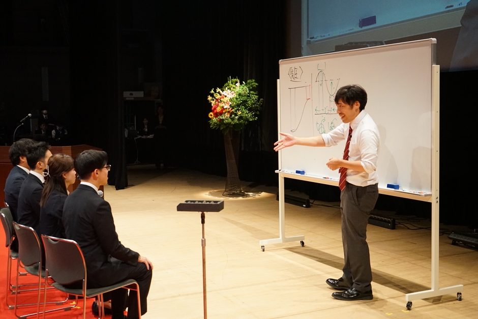 生徒役の社員を指名しながら授業を進める田村先生