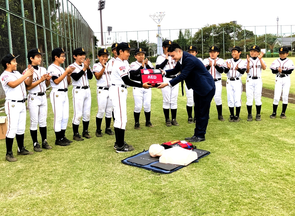 優勝した深川ジャイアンツ選手の皆さん 弊社社員よりキャプテンへAEDの贈呈