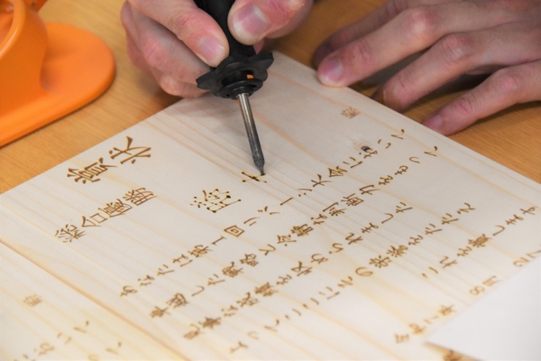 木製の賞状にその場でチーム名を焼付