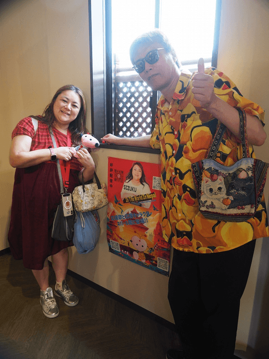 ポスターの前で写真を撮るSIZUKUとGOD