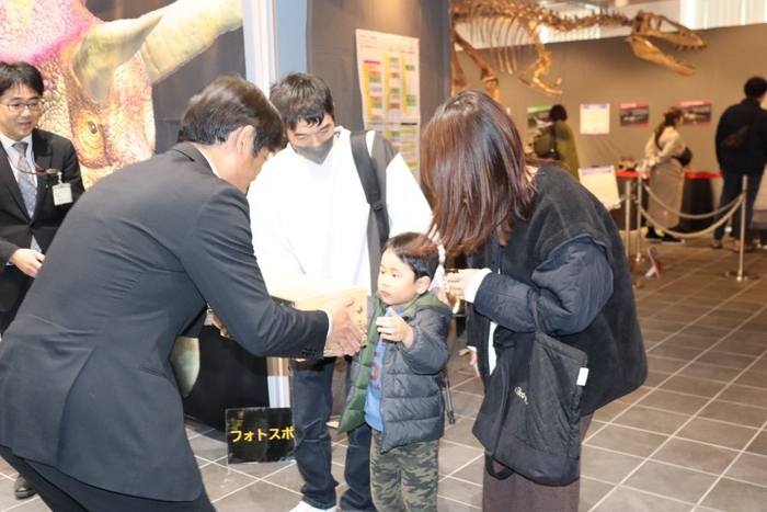 姶良市の堂路温幸・副市長から特産品を受け取る永田結都君