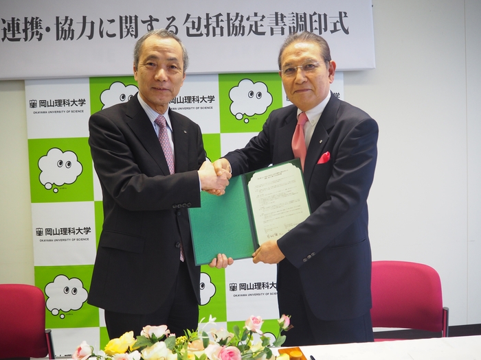 握手をかわす貝畑会長(右)と柳澤学長